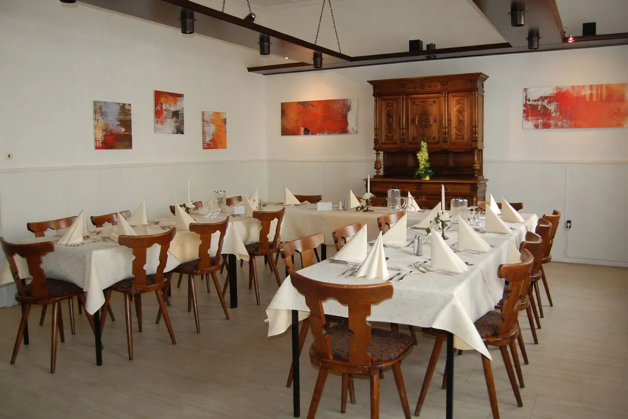 Festlich gedeckte Tafeln mit Serviettenpyramiden im Speisesaal