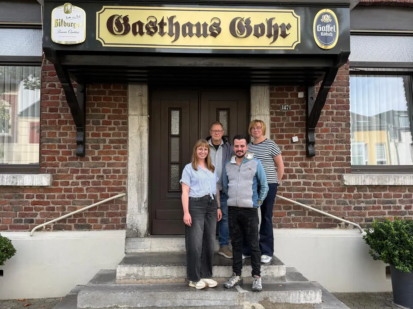Das Team vom Gasthaus Gohr auf der Treppe vor dem Eingang, darüber das Schild in goldener Fraktur